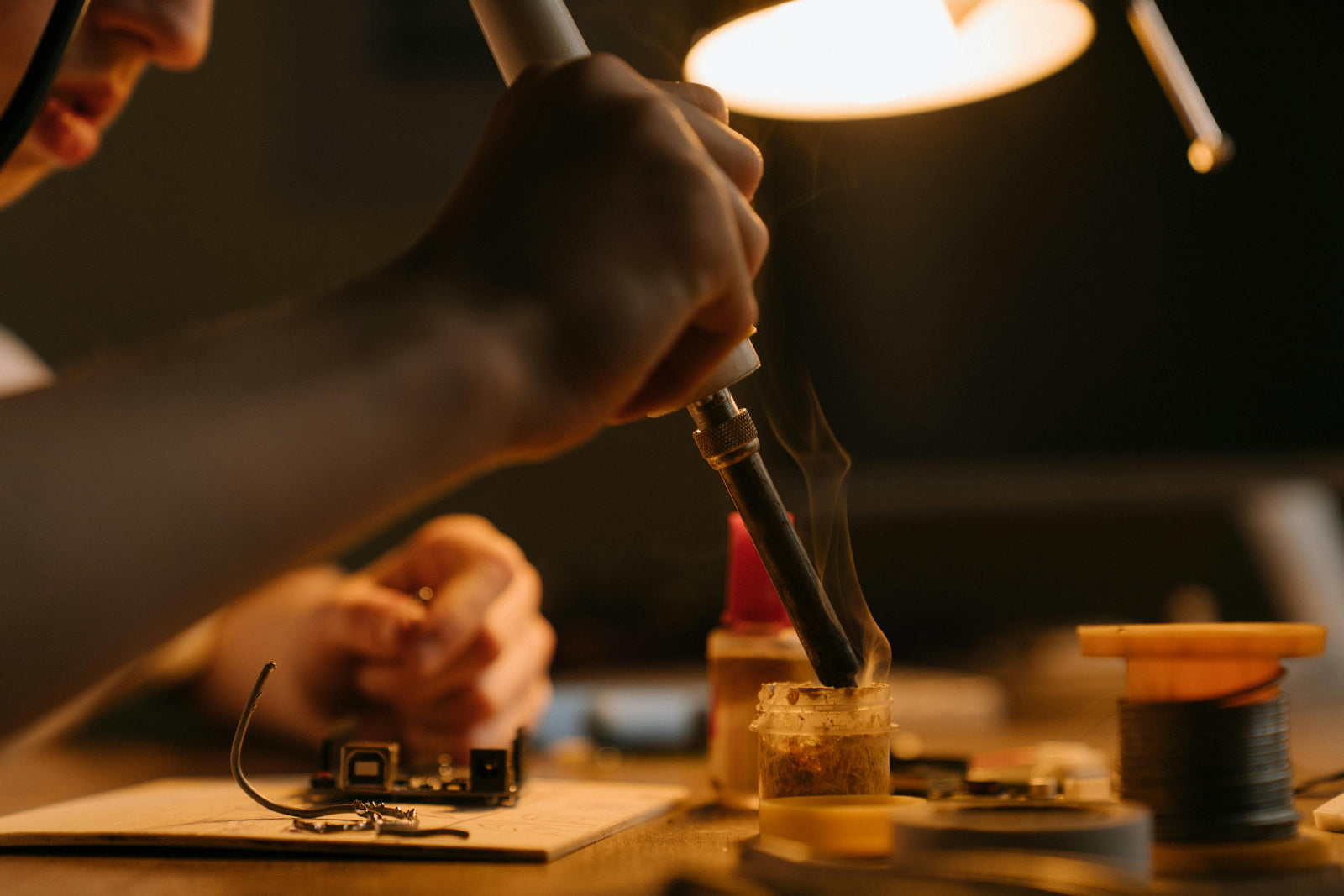 Image of a person using a soldering iron. Photo by cottonbro studio